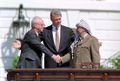 1993年のパレスチナ暫定自治協定調印後，歴史的な握手を交わすイスラエルのラビン首相（左）とパレスチナ解放機構のアラファト議長（右）を前にしたクリントン（中央）.jpg